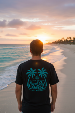 Back of Under the Palms Tee Teal on man at Florida beach golden hour