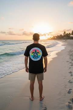 Back of Local Sol Badge Tee showing colorful sea turtle badge graphic on beach